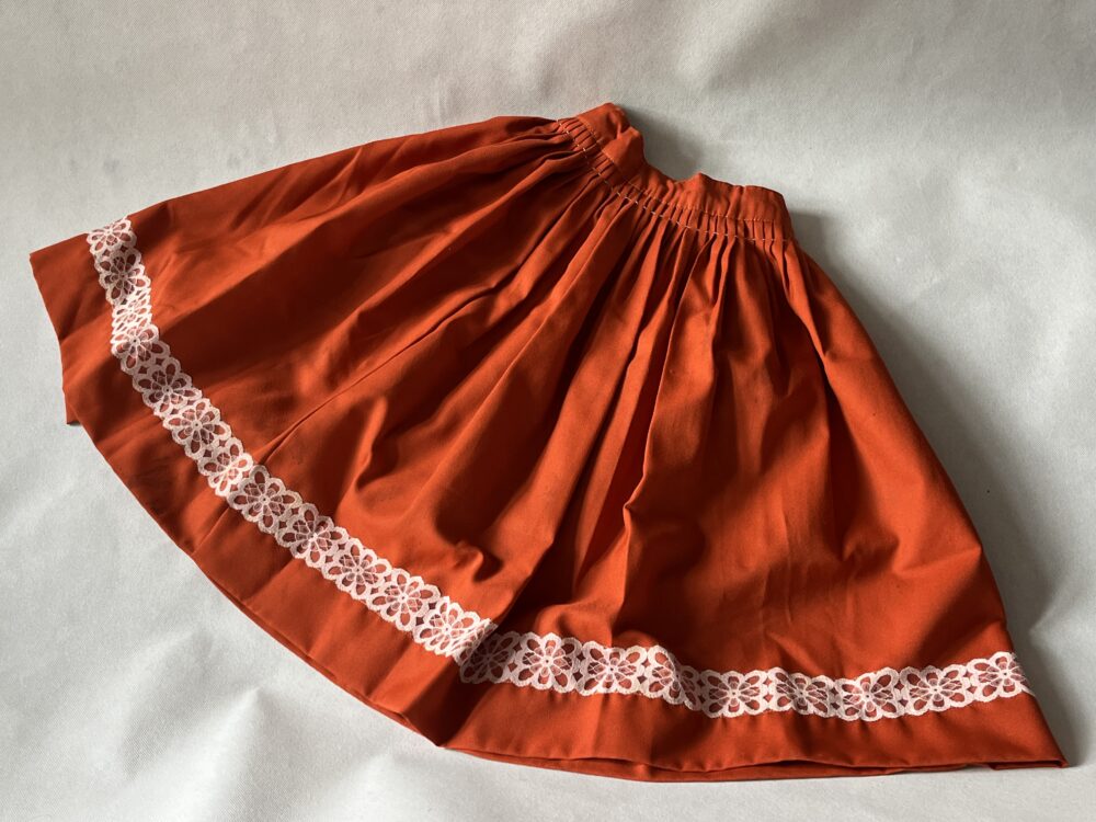 Součást lidového kroje - Oranžová sukně s krajkou