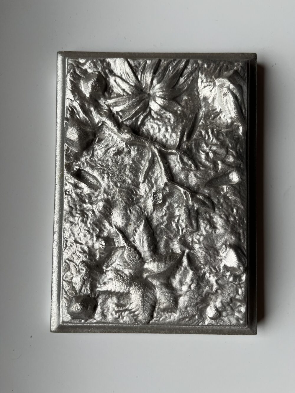 Dekorativní předmět z cínu - reliéf s motivem listů a květin