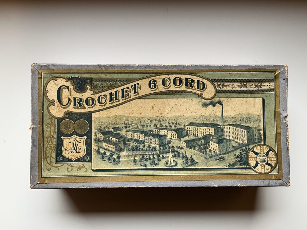Starožitná krabička od příze s vyobrazením továrny + 8 špulek nití